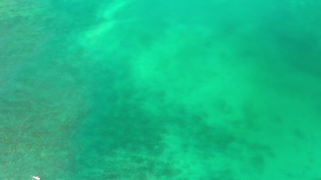 Bright green water over mottled seabed