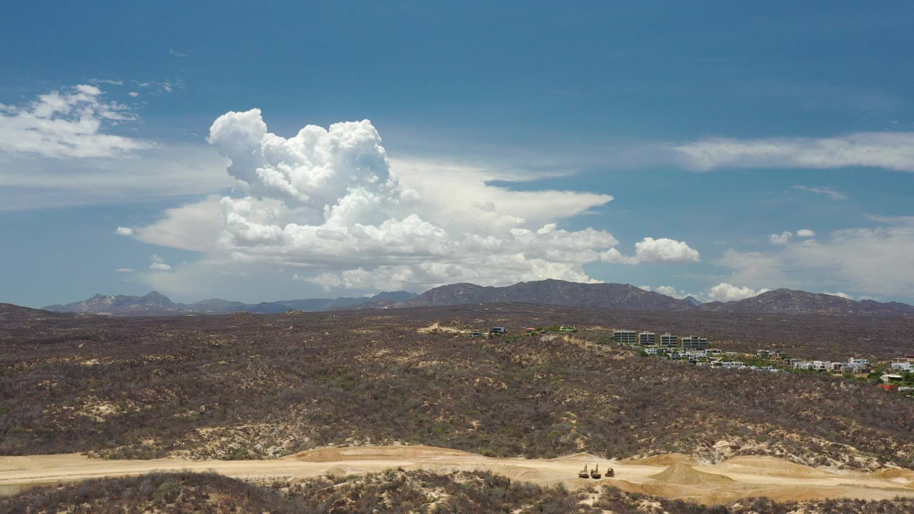 Wide desert overlook with mountains and large clouds