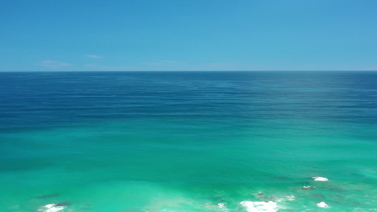 Opening frame of the Los Cabos, Mexico ocean view, with turquoise water below, deep blue water near the horizon, bright sky above, and no visible people.