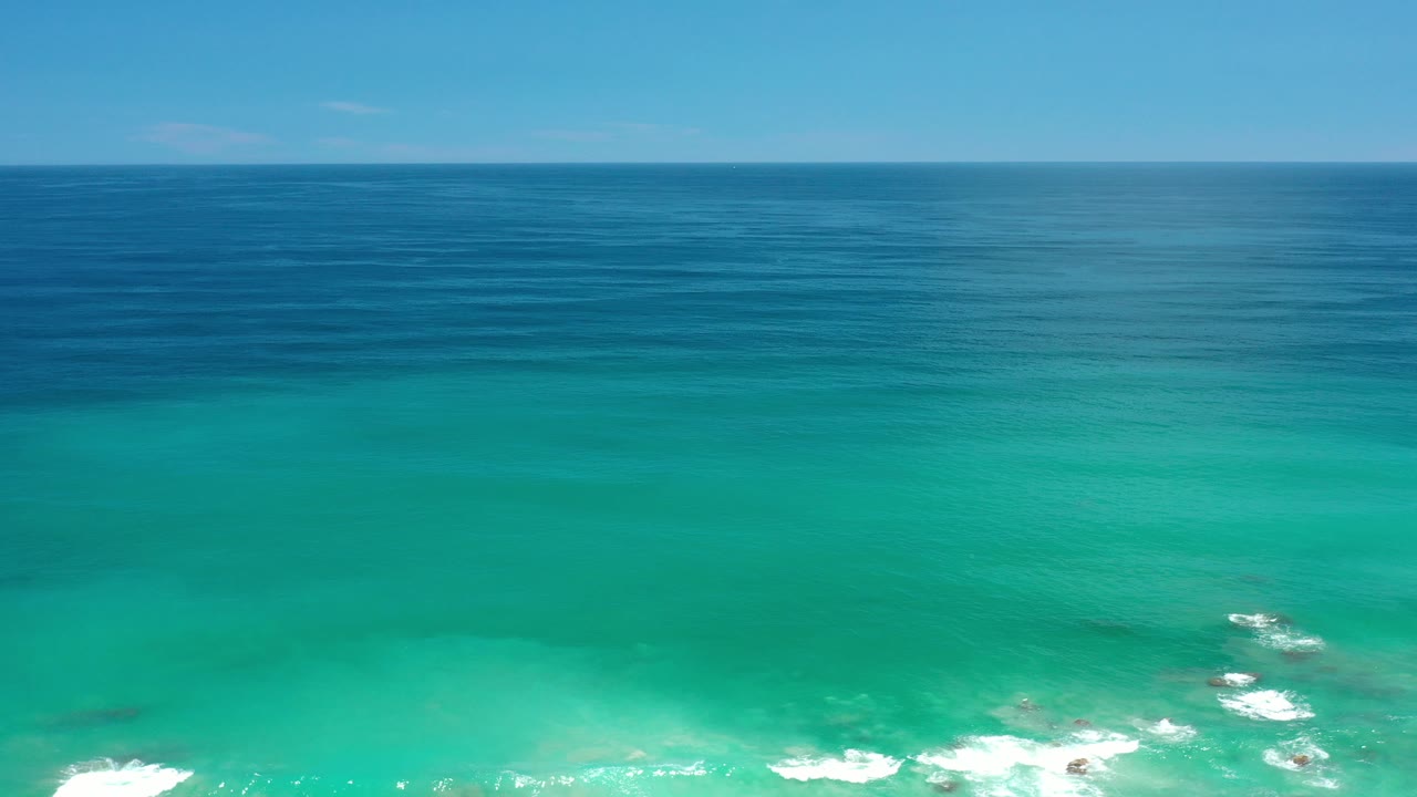 Blue ocean horizon above clear green water