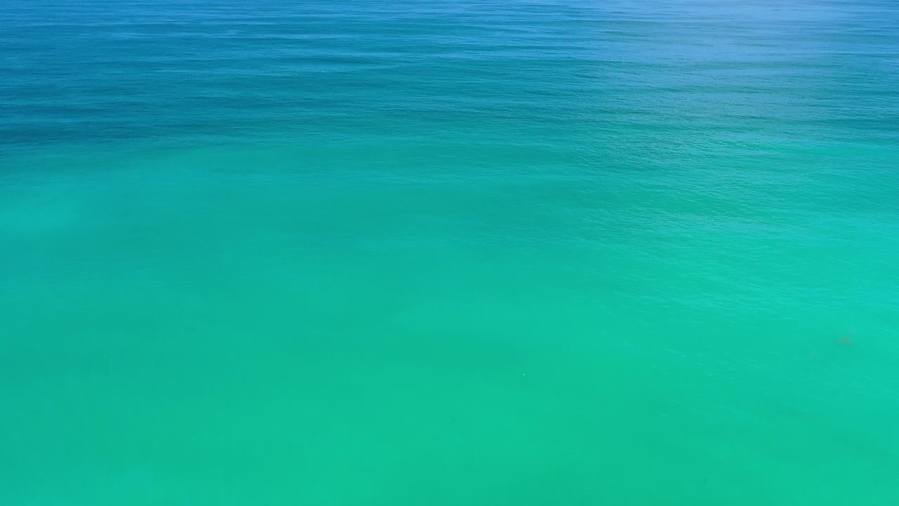 Open turquoise sea with darker water across the upper frame