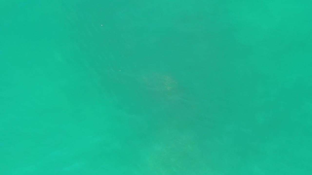 Clear ocean water with darker underwater patches