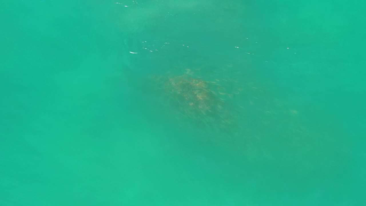 Clear green-blue ocean water in Los Cabos, Mexico, with small highlights near the upper edge and no visible people.