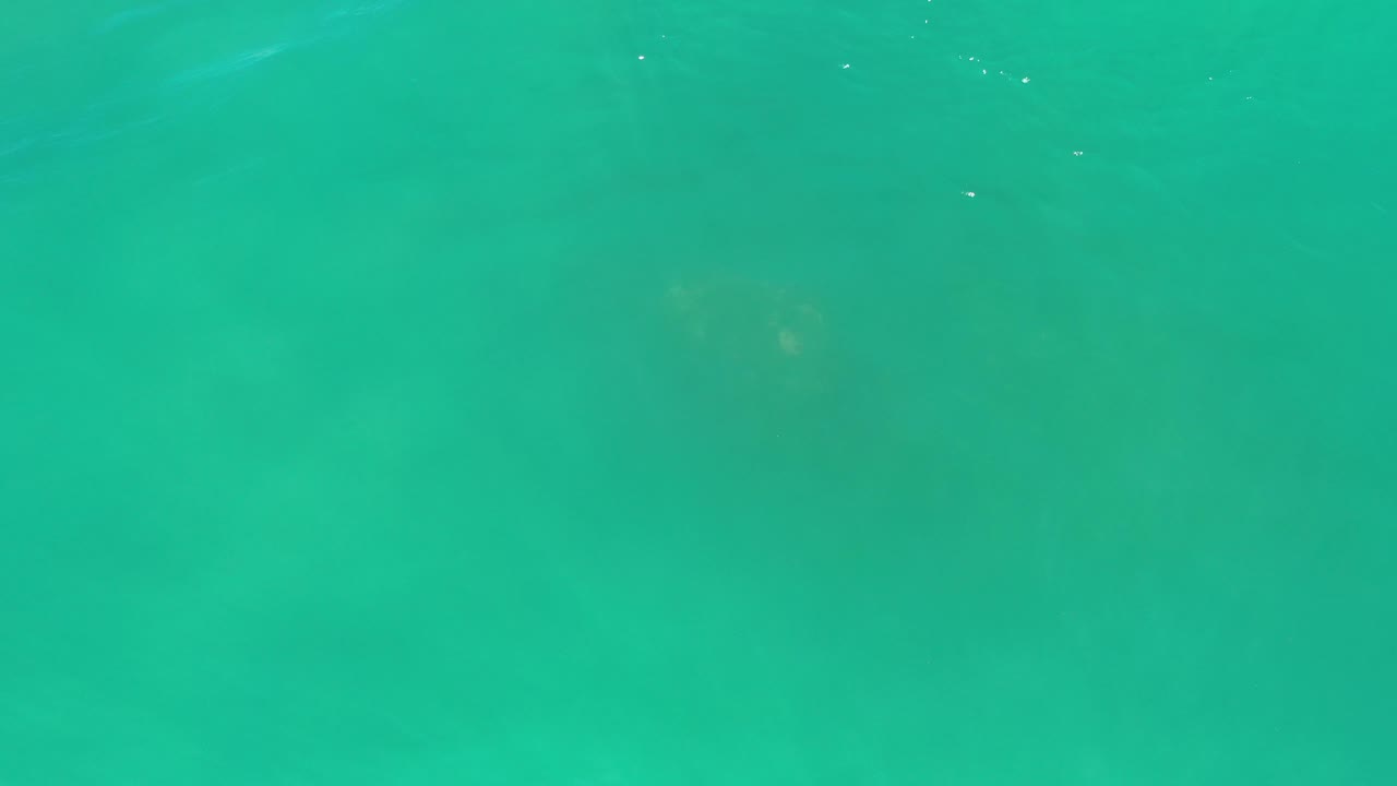 Teal ocean water with darker submerged patches
