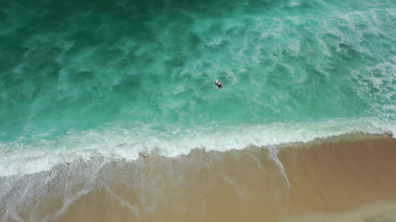 White surf band crossing tan sand