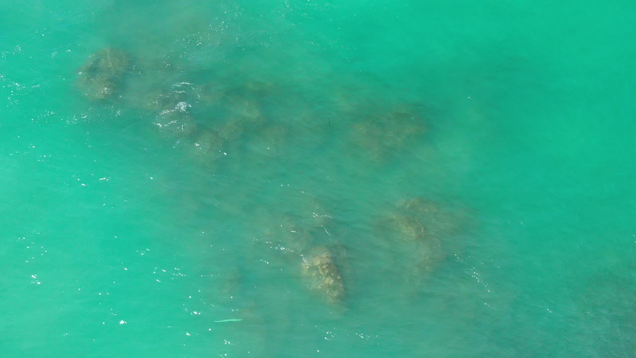 Turquoise water over submerged brown reef patches