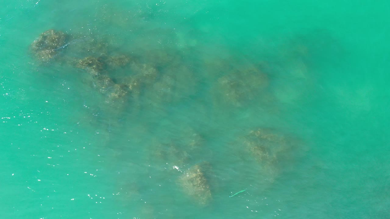 Shallow turquoise water with scattered rocks
