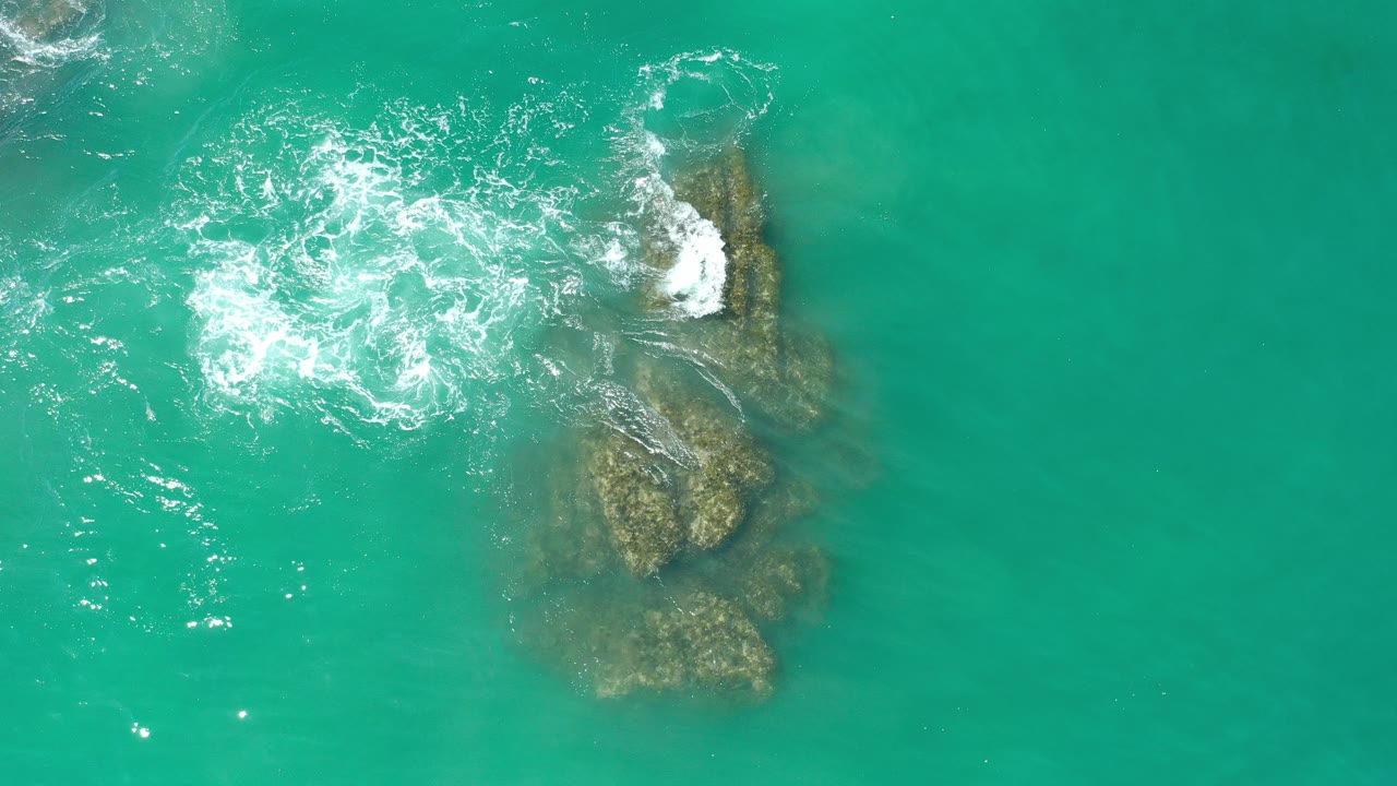 Turquoise water washing over submerged coral or rock