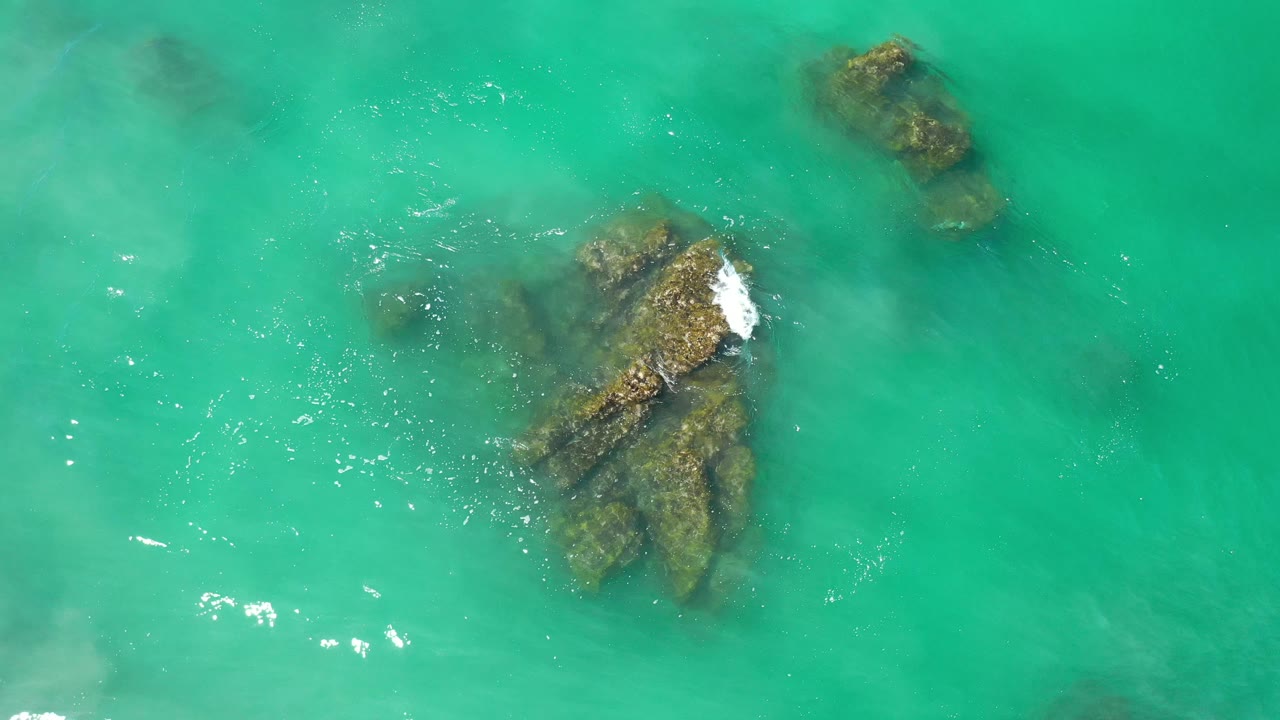 Wave foam beginning on the upper rock