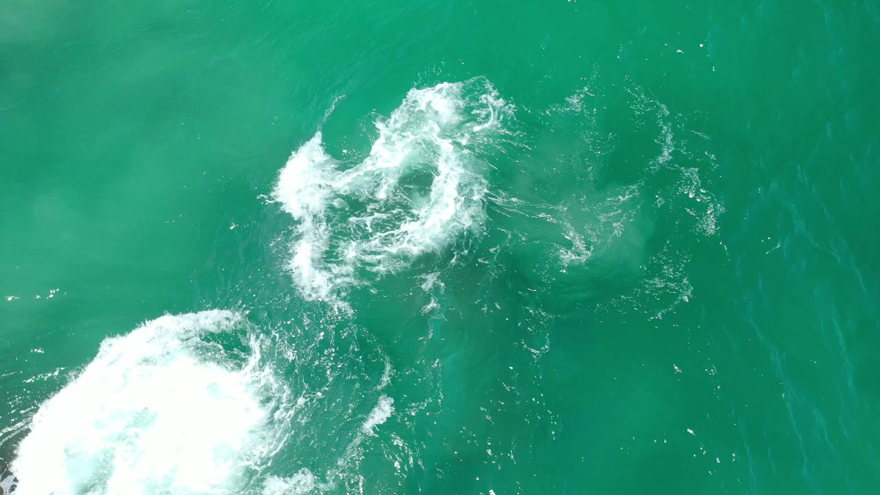 White surf patches swirling over turquoise water