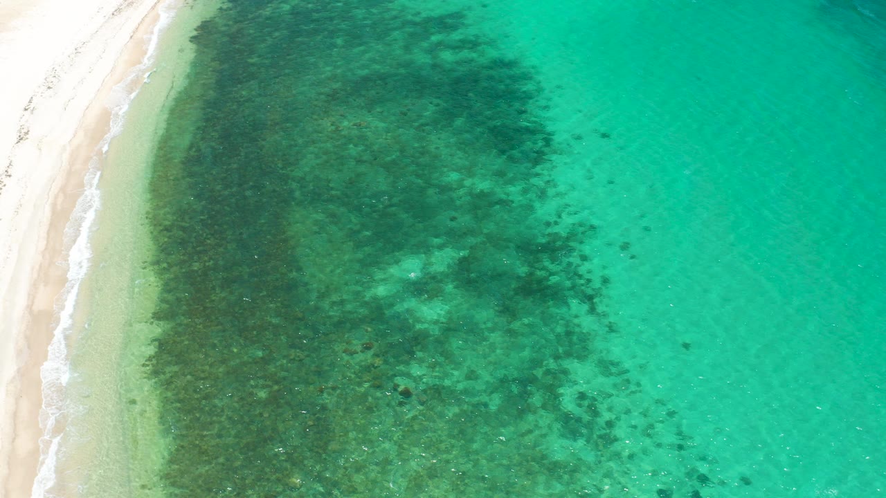Overhead shoreline with pale sand and turquoise shallow water