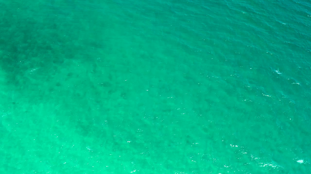 Green-blue ocean surface in El Sargento La Ventana, Mexico, seen from above with scattered white wave glints and no visible people.