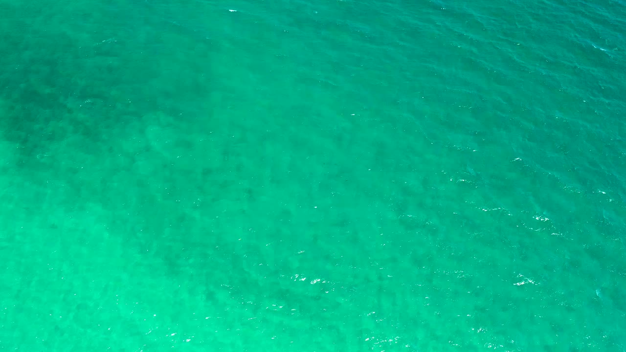 High overhead view of clear aqua water in El Sargento La Ventana, Mexico, with light ripples crossing the frame and no visible people.
