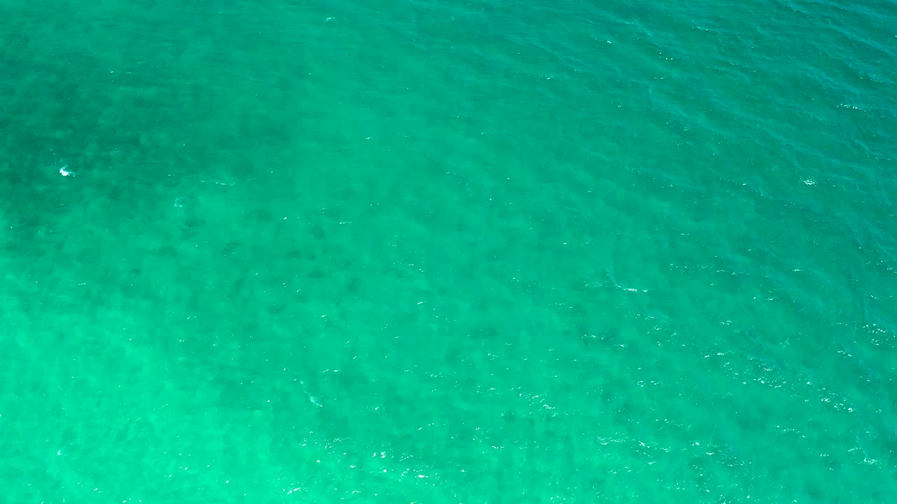 Blue-green seawater fills the overhead frame in El Sargento La Ventana, Mexico, with soft ripples, faint submerged texture, and no visible people.