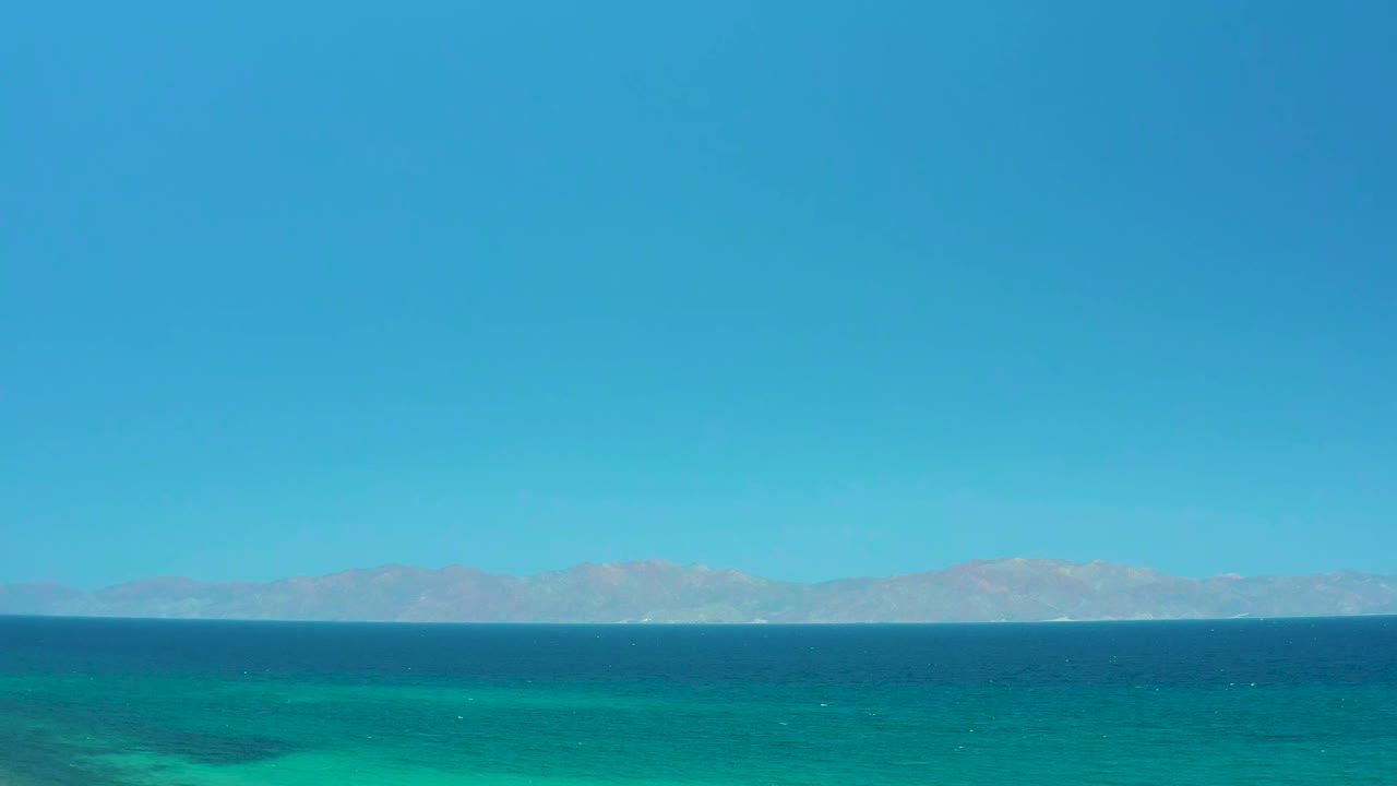 At one second, the El Sargento La Ventana, Mexico view keeps the horizon low with turquoise water in the lower frame, muted mountains in the distance, and no visible people.