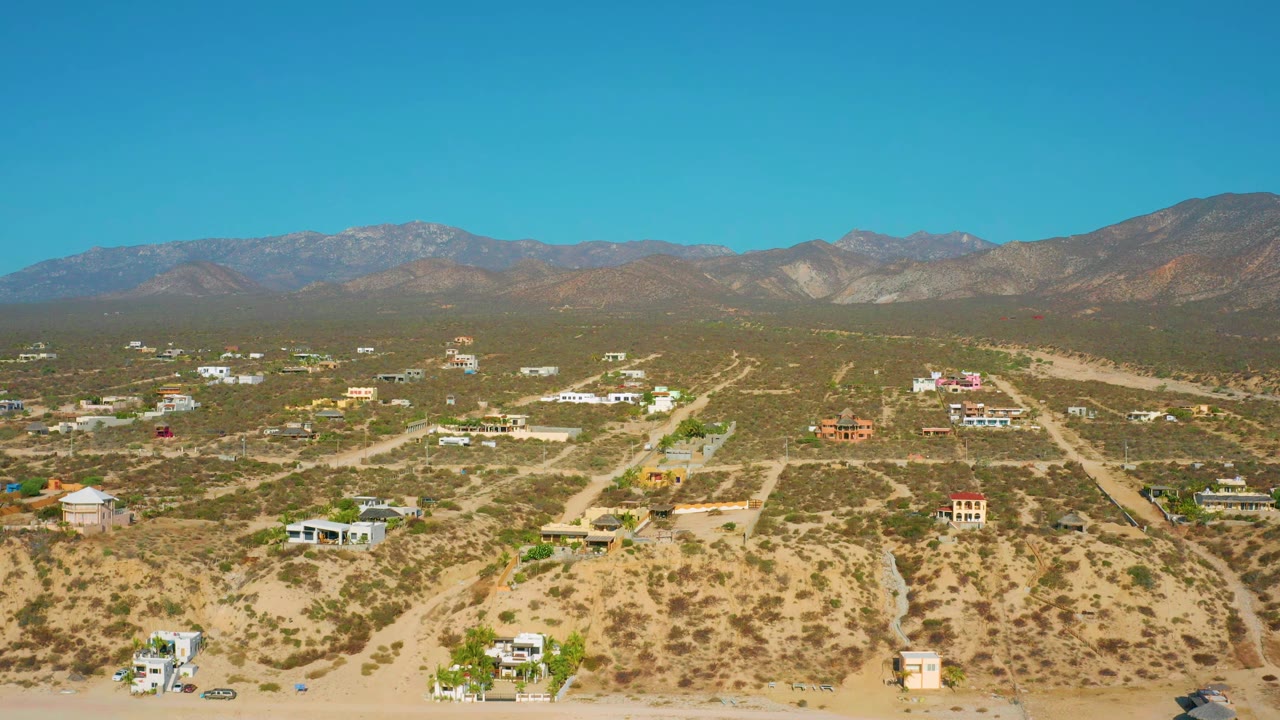 Sunlit desert neighborhood with mountains in the distance