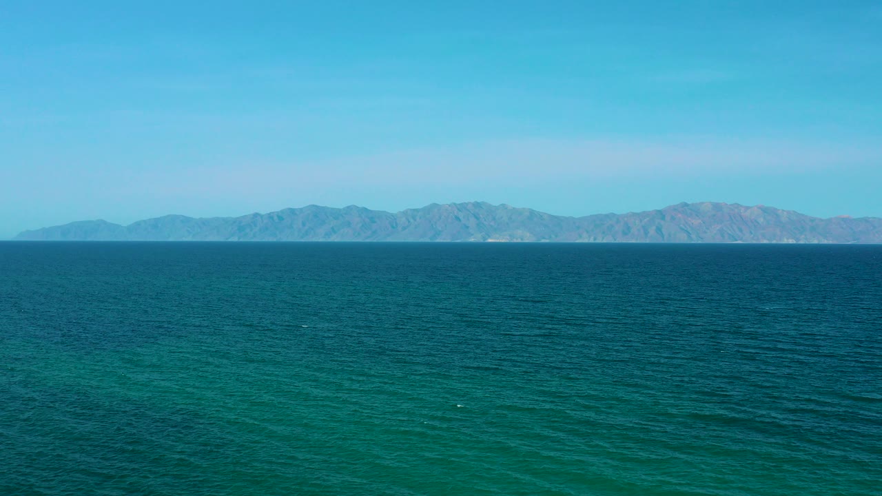 Opening frame of El Sargento La Ventana, Mexico, showing blue-green water across the foreground, a distant mountain range on the horizon, and no visible people.