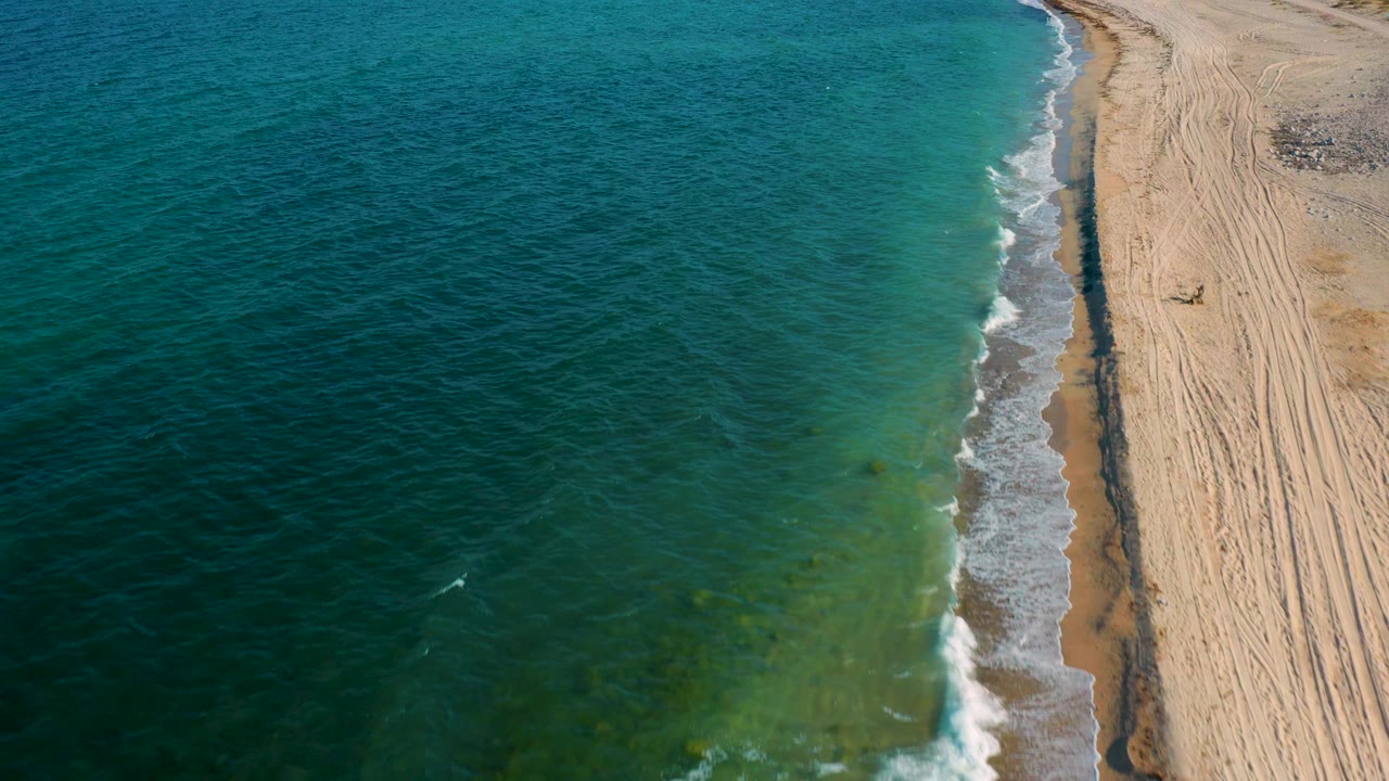 Ocean and straight sandy shoreline seen from high above