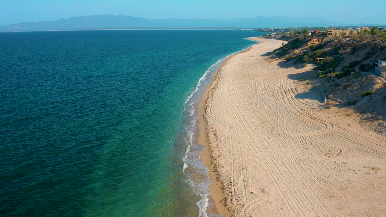Diagonal shoreline with turquoise water and pale raked sand