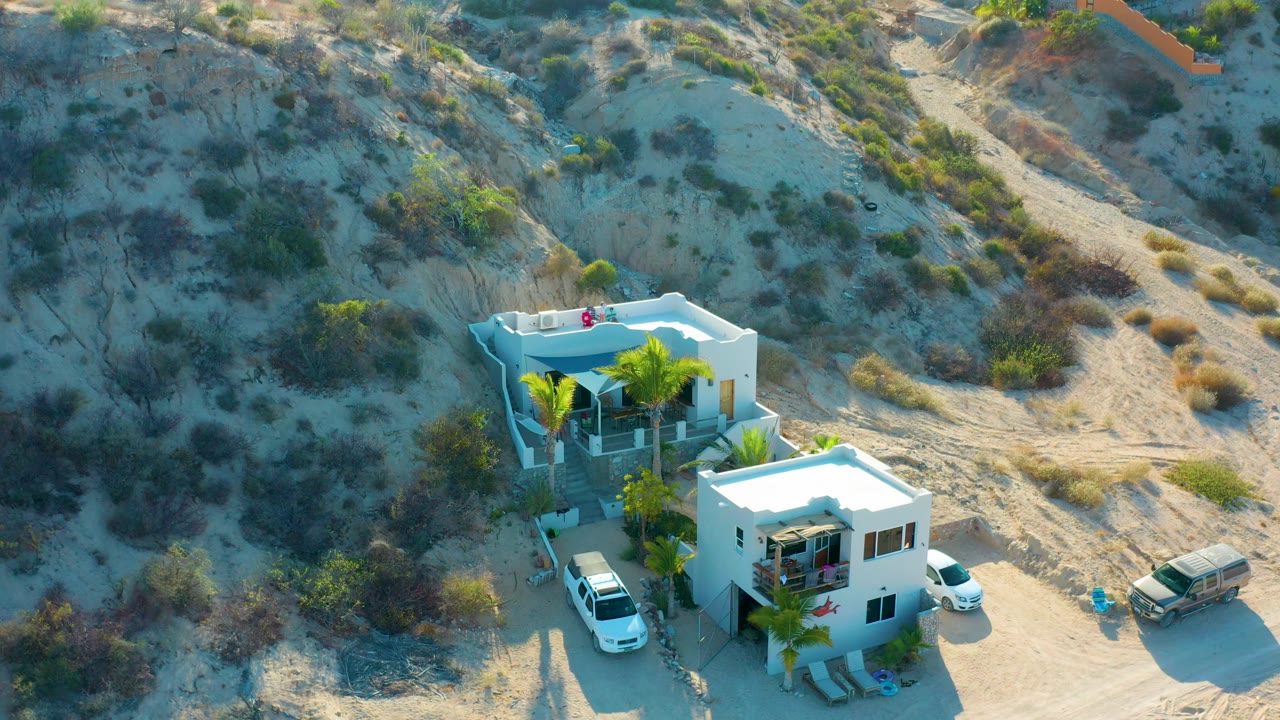 Drone view of desert hillside behind white homes