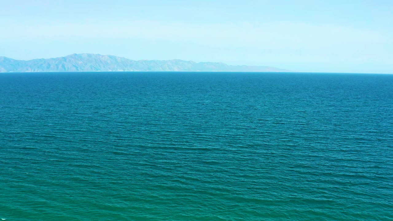 Rippling turquoise and blue sea fills the frame near El Sargento La Ventana, Mexico, with a pale sky and no visible people.