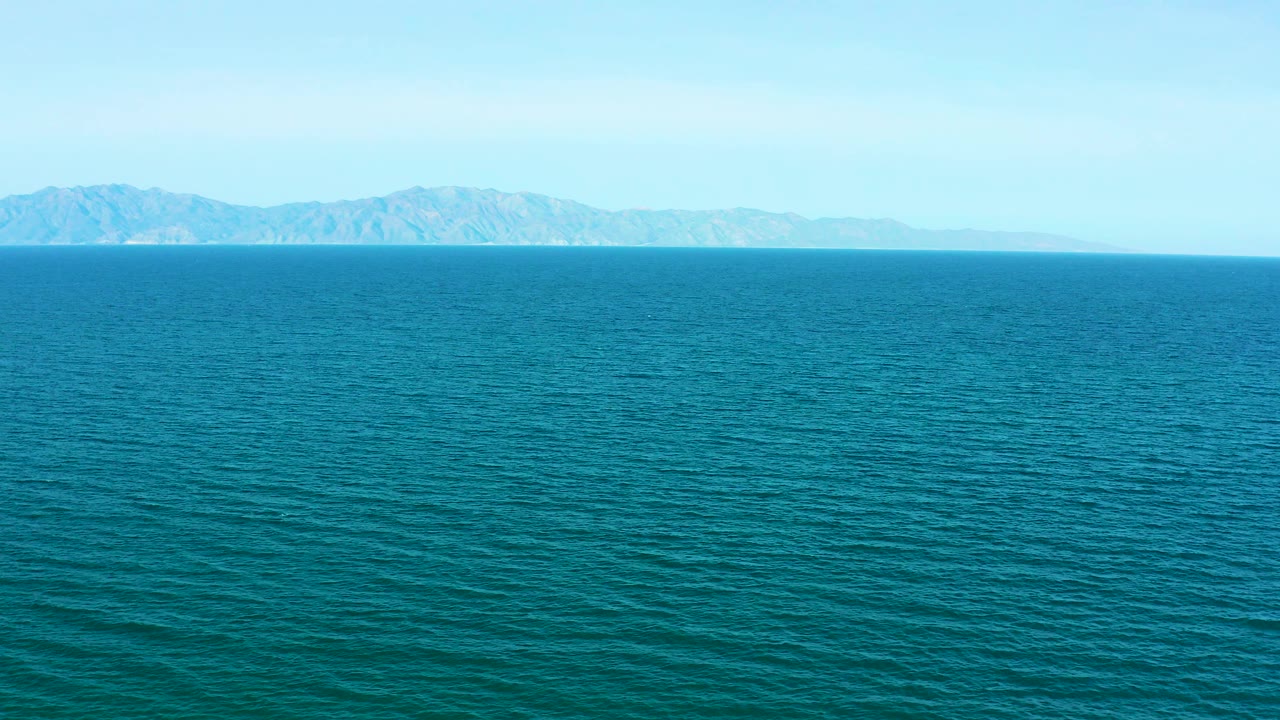 Wide view of blue-green water and distant mountains in El Sargento La Ventana, Mexico, with a level horizon and no visible people.