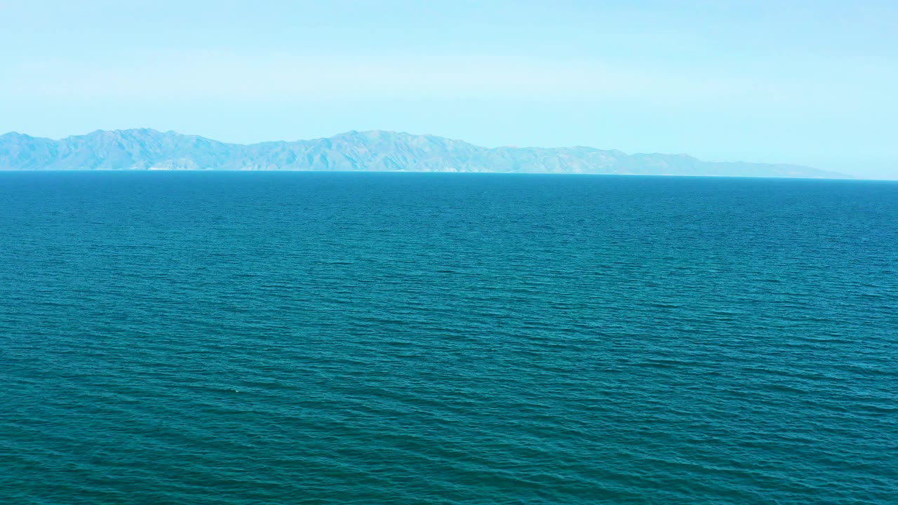 Second frame shows the same open El Sargento La Ventana water view with slightly shifted wave texture, distant mountains spanning the horizon, clear sky, and no visible people.