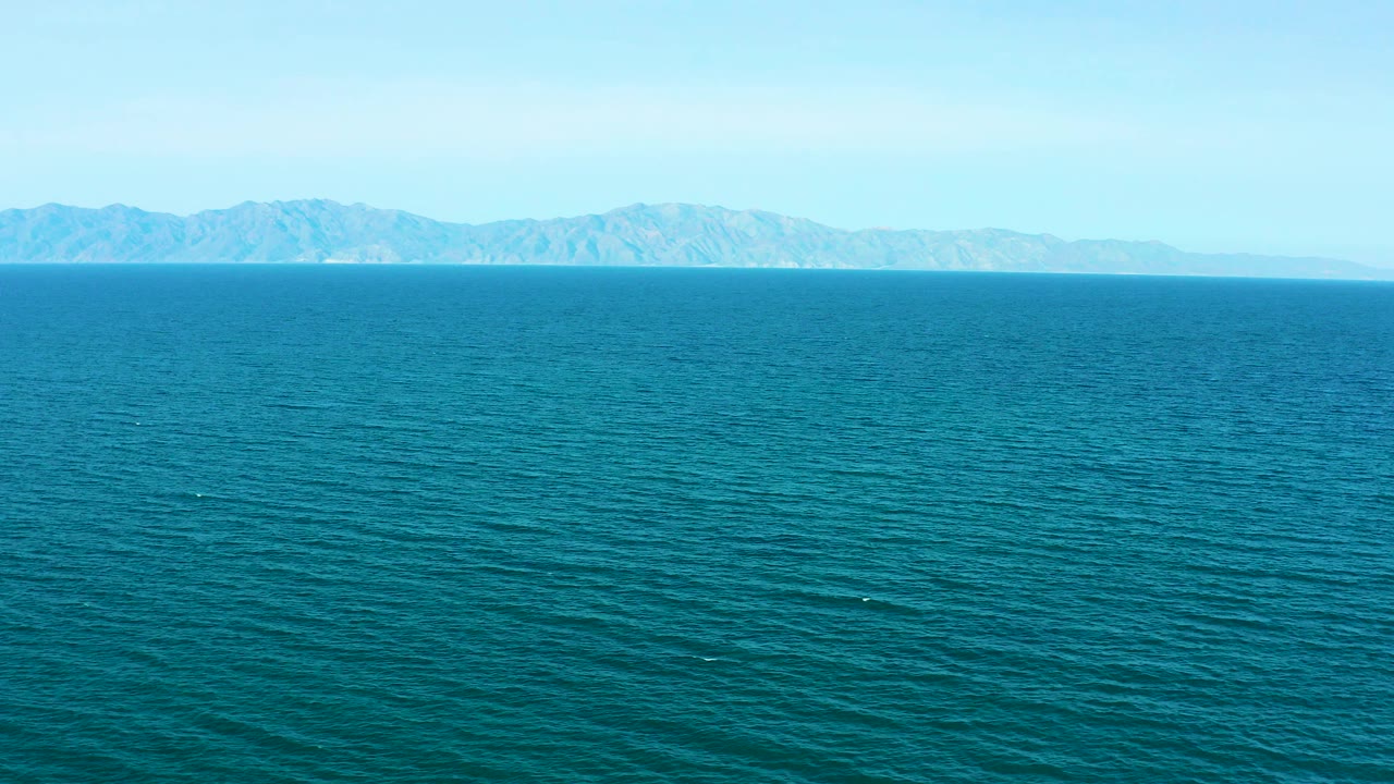 Wide blue ocean with distant mountain coastline on the horizon
