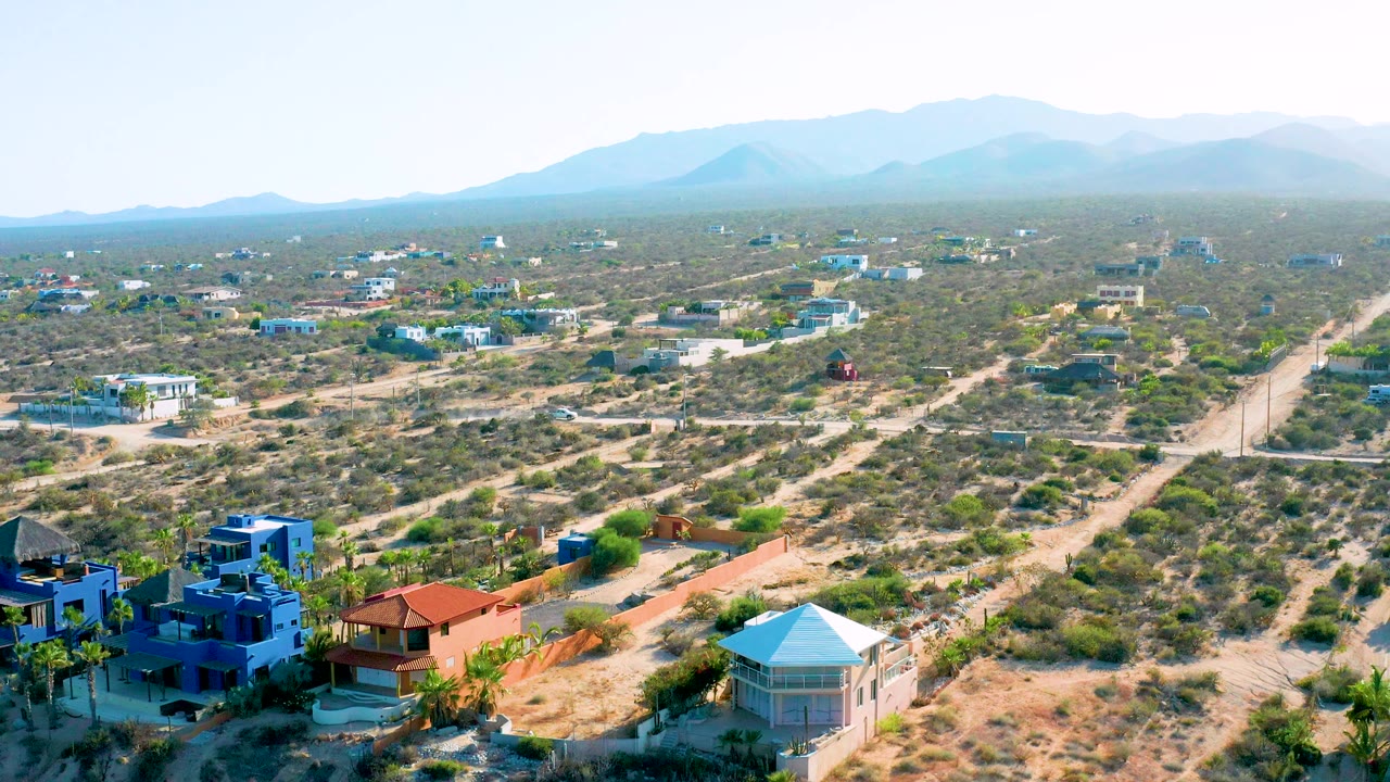 Wide overhead view of scrubland roads and scattered buildings.