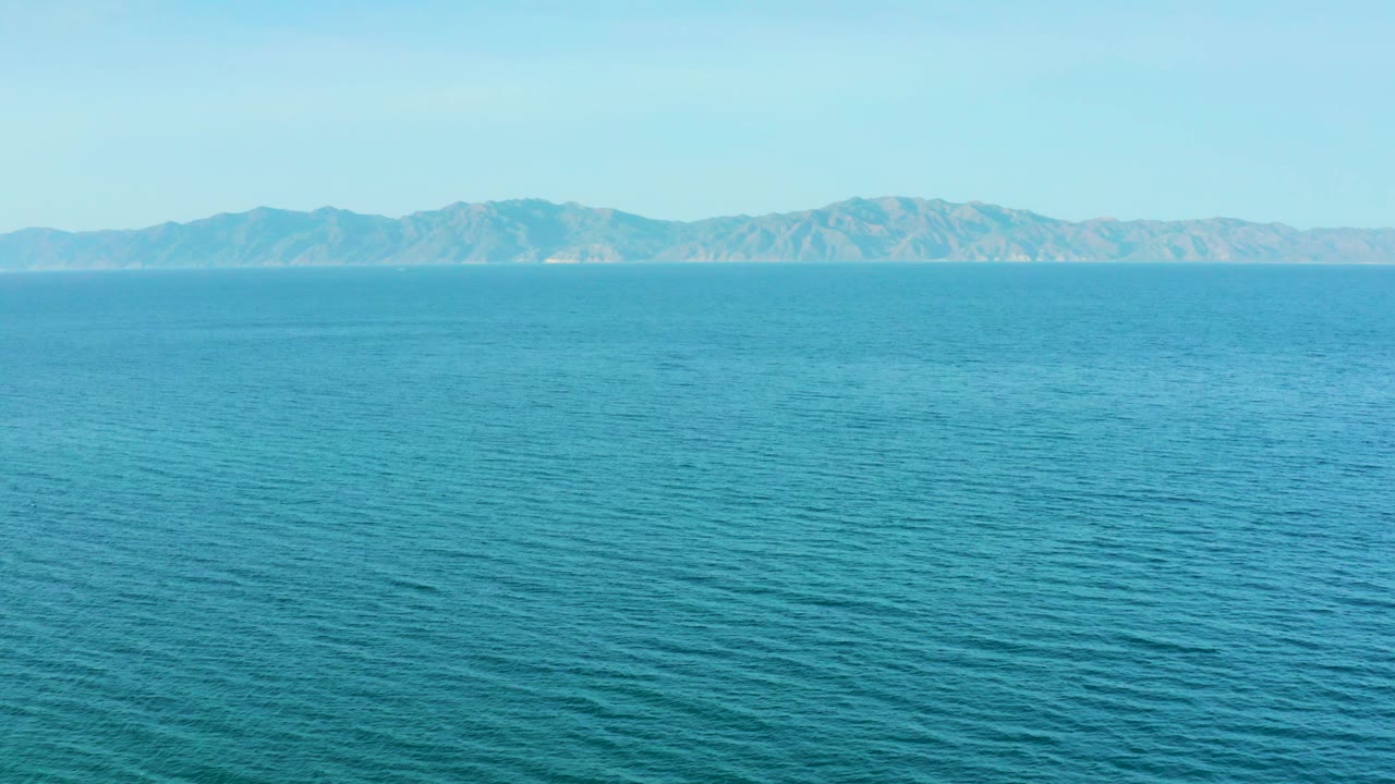 Wide ocean surface with a low mountain ridge in the distance