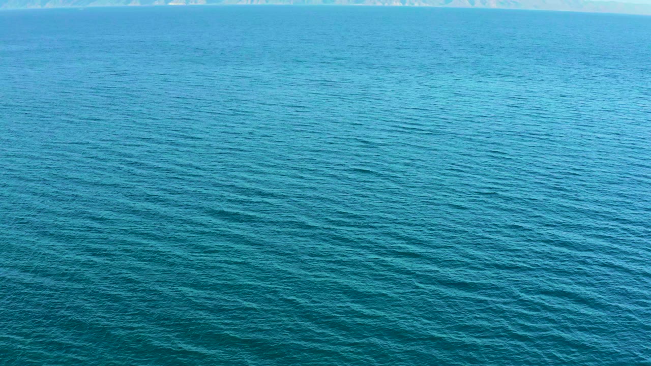 Open blue water with textured ripples and a pale horizon.