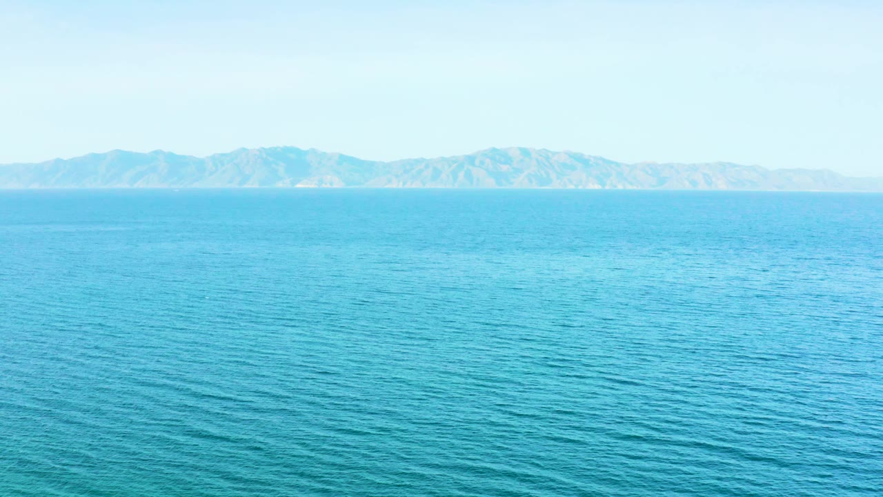 Open ocean surface in El Sargento La Ventana, Mexico, with turquoise-blue water below a pale sky and distant landforms, with no visible people.