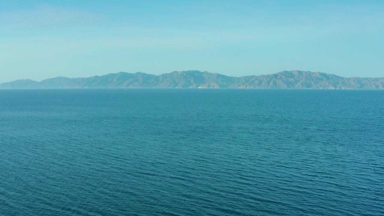 At 0:00, a wide view in El Sargento La Ventana, Mexico shows blue ocean stretching to distant mountains beneath a clear sky, with no visible people.