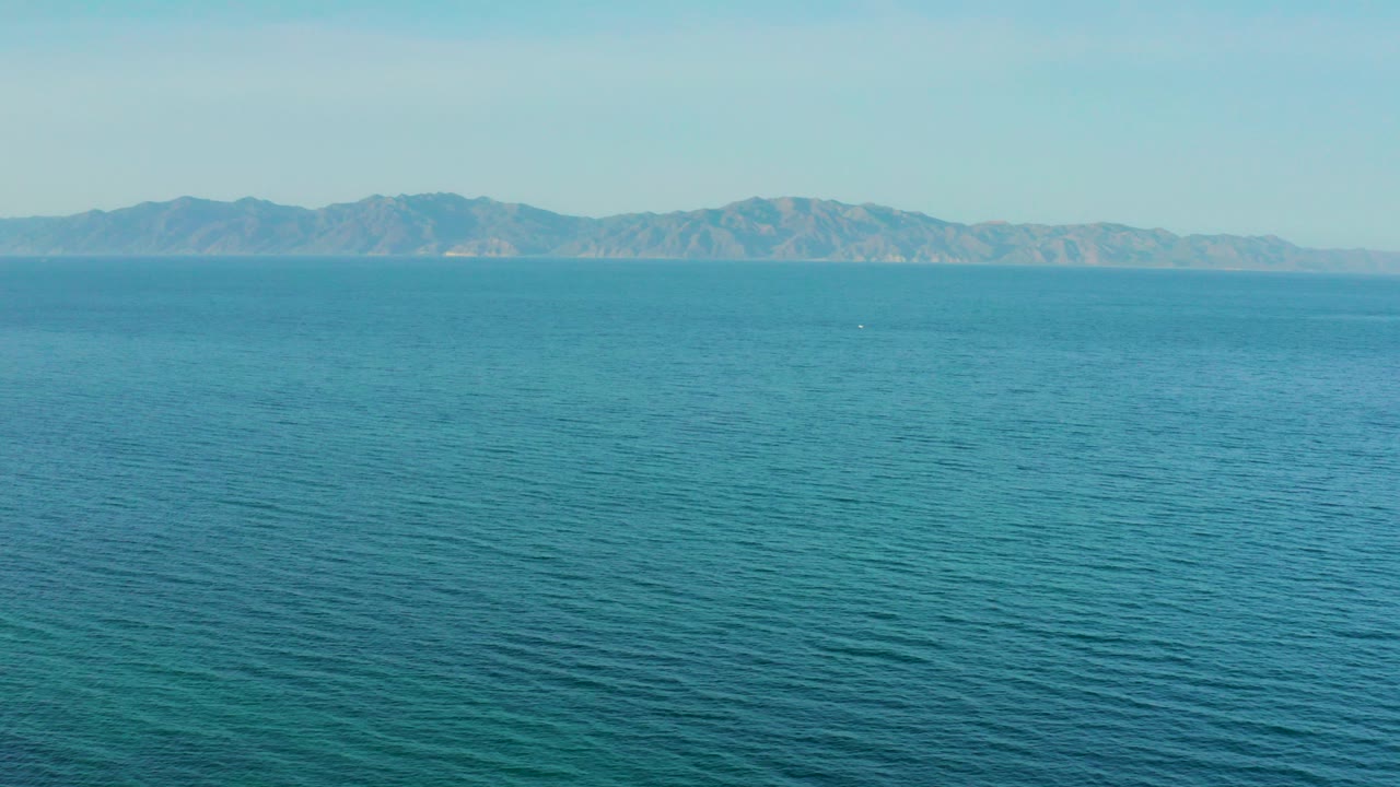 Opening view over blue ocean toward distant mountains near El Sargento La Ventana, Mexico, with a level horizon and no visible people.