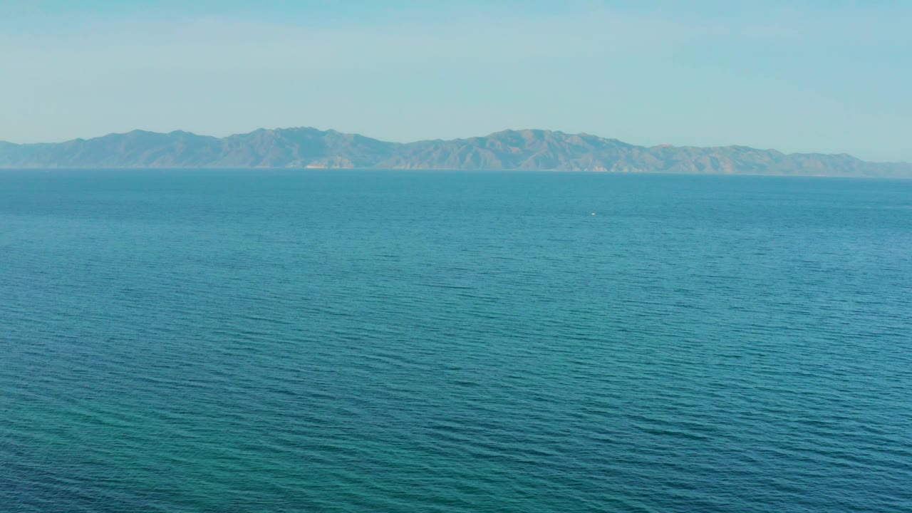 Distant mountain coastline beyond blue water