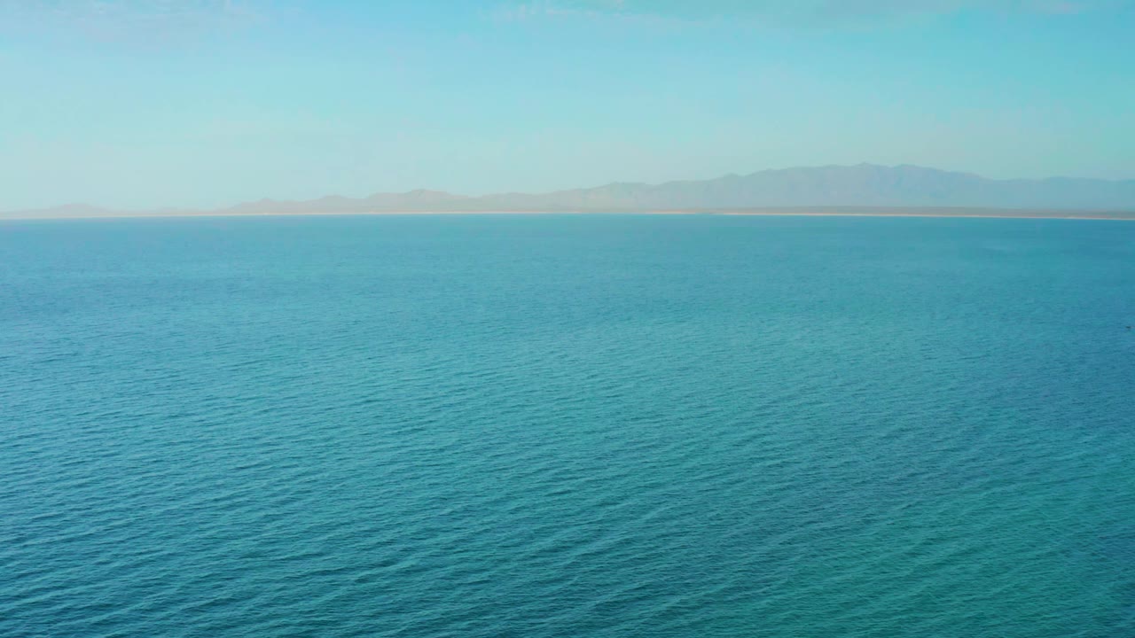 Calm blue sea with faint mountain horizon