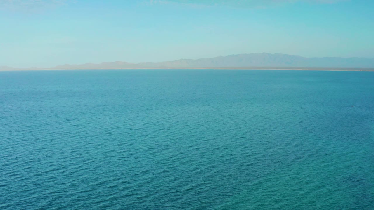 Blue sea with faint land and mountains in the distance