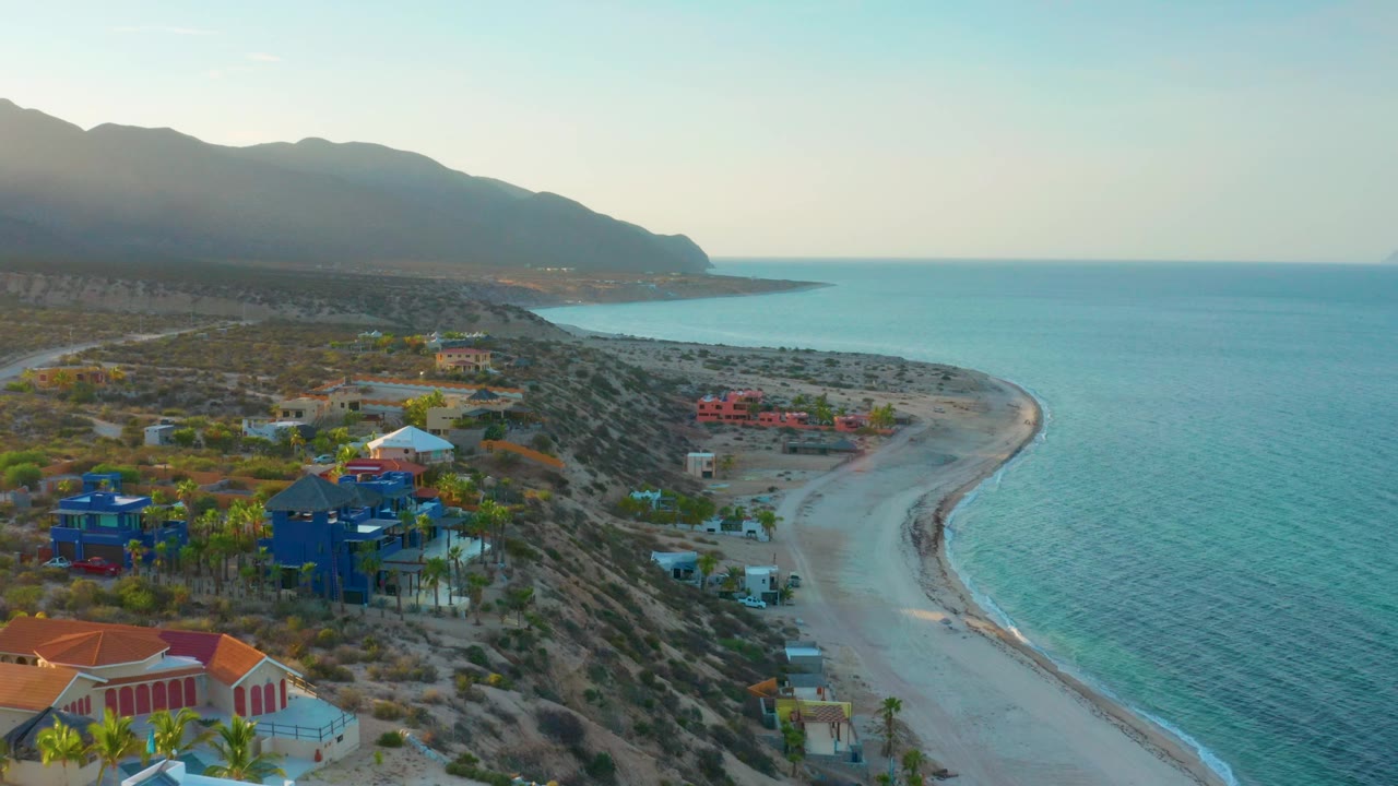 High view of coastal neighborhood above an empty beach and calm water