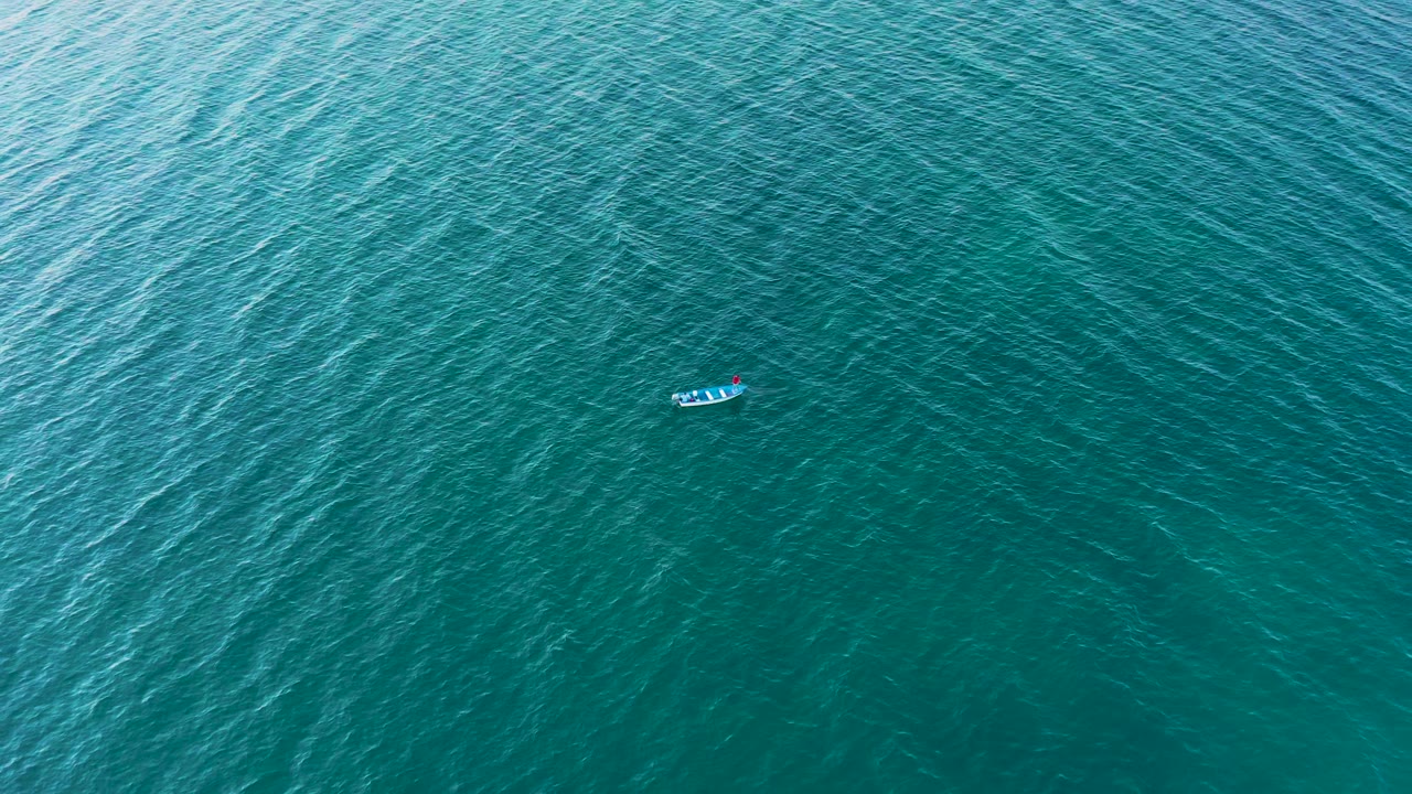Small boat lower in a wide ocean view