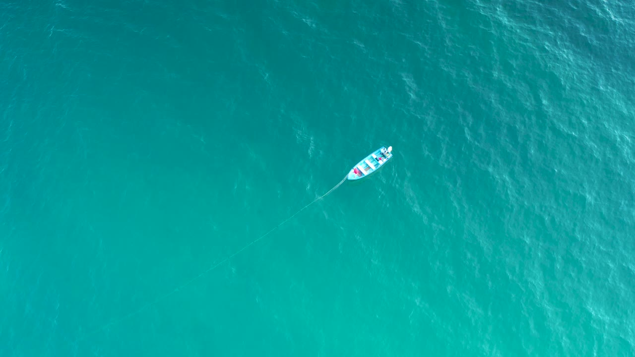 The white boat appears left of center on green-blue ocean in El Sargento La Ventana, Mexico, with a thin line extending behind it and no visible people.