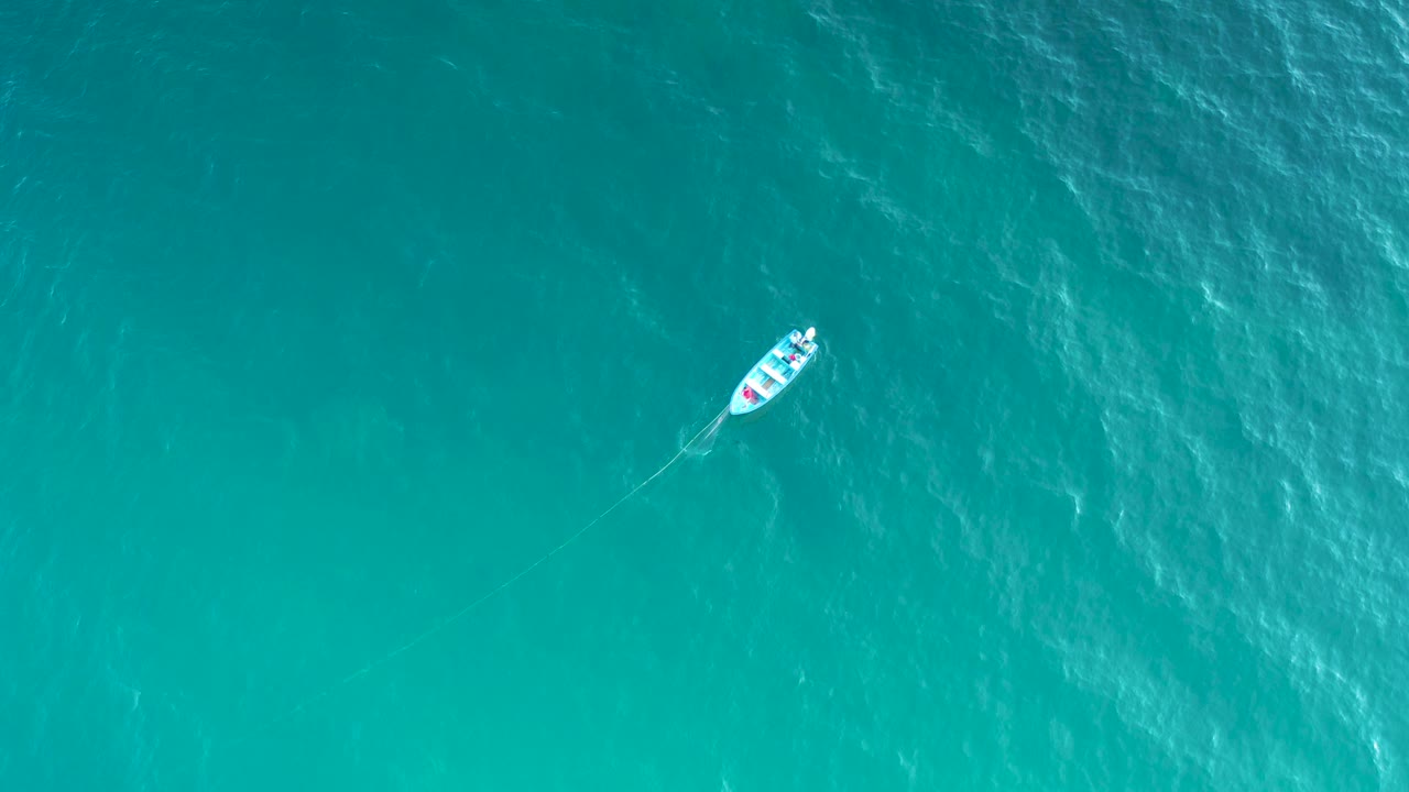 The boat appears left of center over open aqua water in El Sargento La Ventana, Mexico, with a diagonal wake line and no visible people.