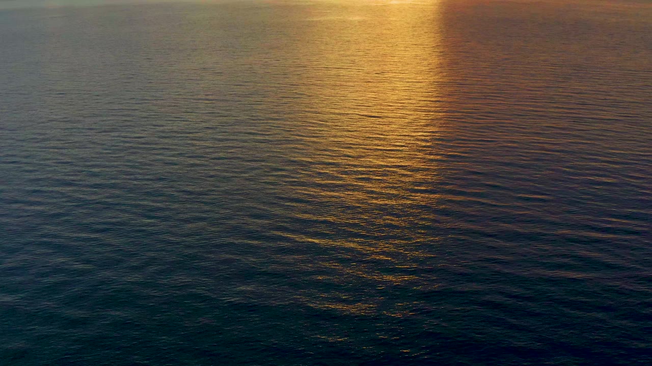 Sunset reflection over gently rippled sea surface