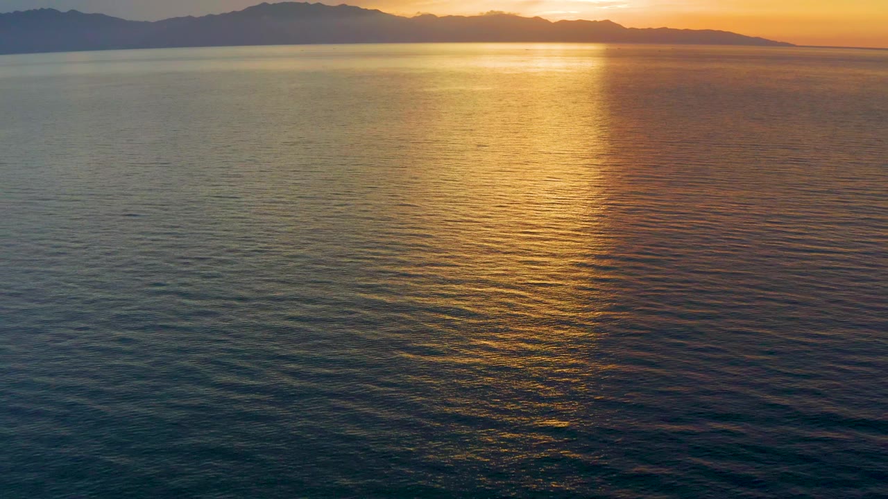 Fourth frame shows the gold reflection dropping through the center of the El Sargento La Ventana ocean view, with shadowed mountain forms along the horizon and no visible people.