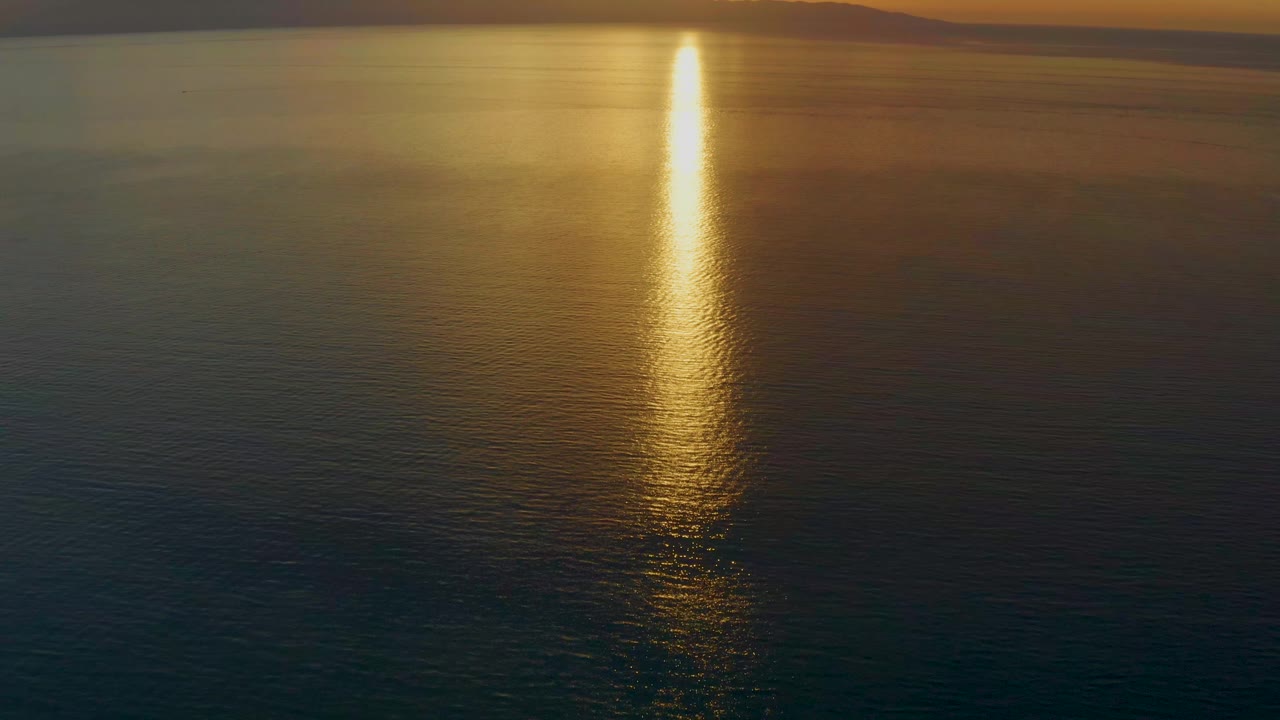 At 0:01, the El Sargento La Ventana frame holds on open water with the sun reflection slightly right of center, layered golden water, distant mountains, and no visible people.