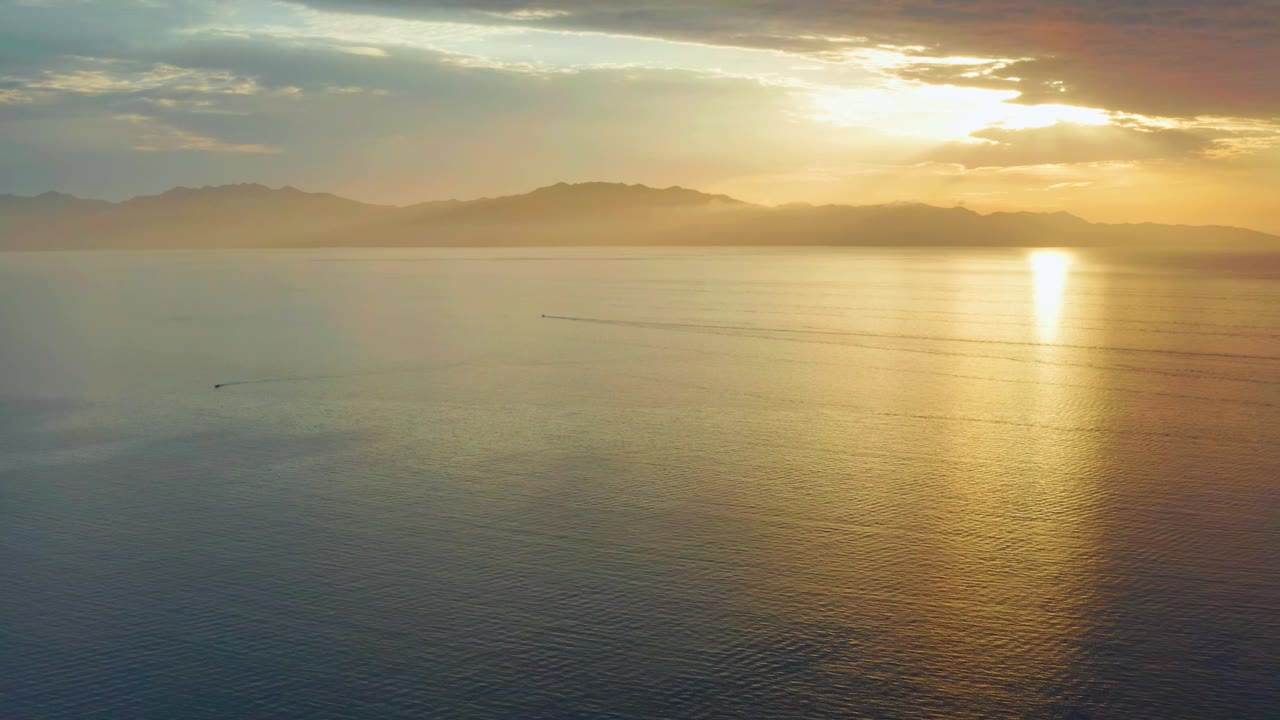At 0:01, the El Sargento La Ventana view holds on open water with the sun reflection slightly right of center, muted blue water at left, distant mountains, and no visible people.