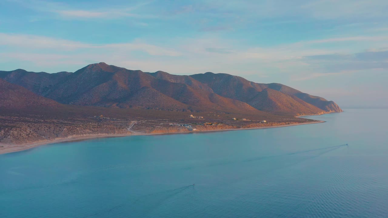 Coastline with calm blue water and mountain range