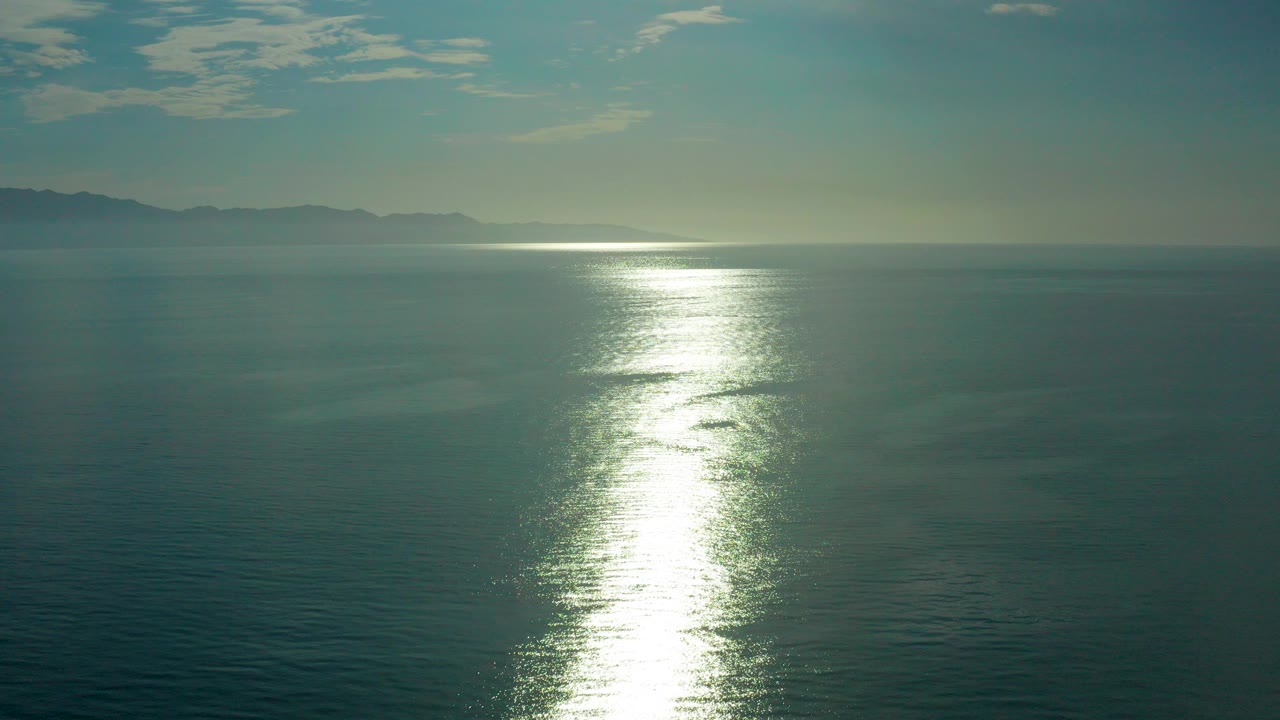 Wide ocean horizon with bright sun reflection on the water