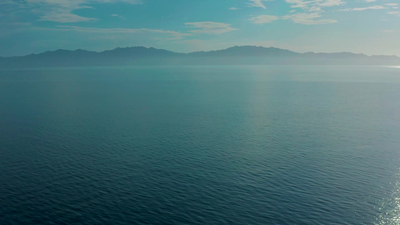 Calm open water leading to a hazy mountain range