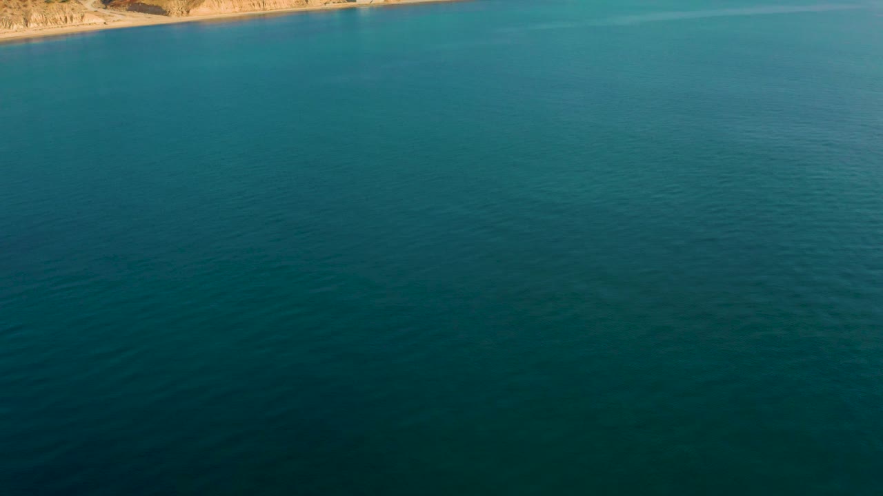 Open turquoise water with a sliver of rocky shoreline in the background.