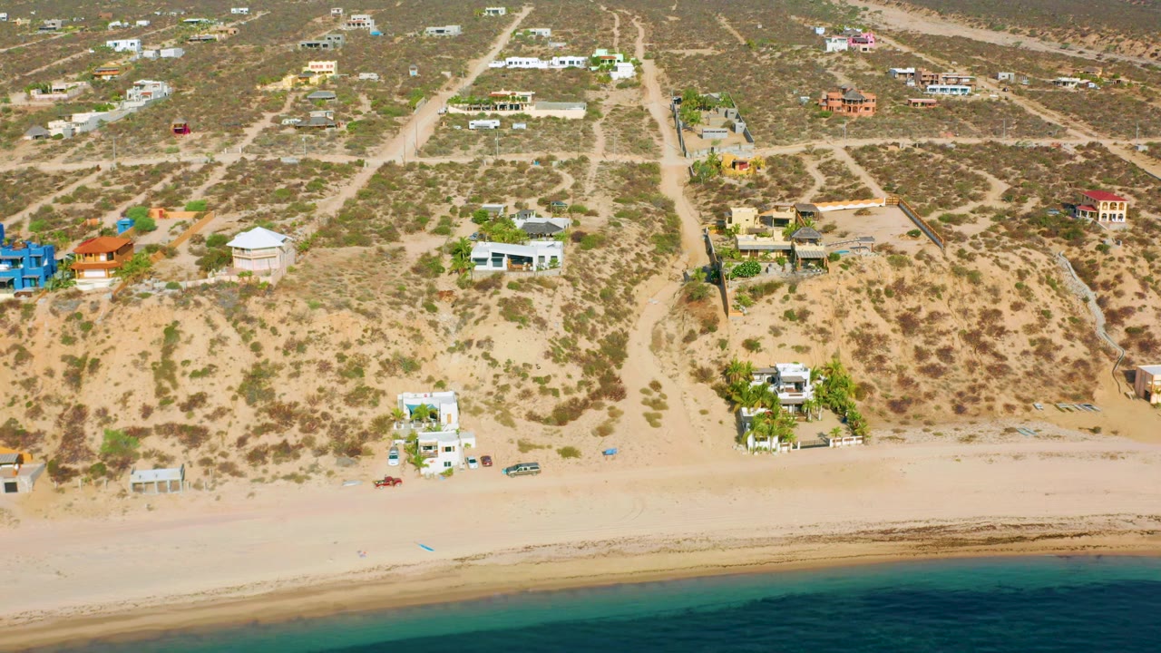 Overhead coastal homes beside a quiet sandy beach